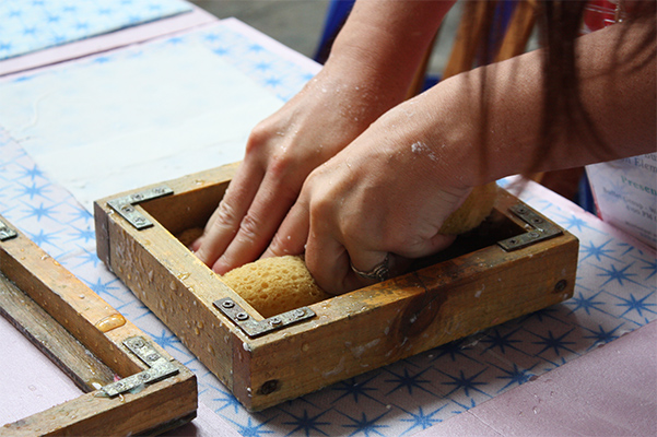 close up of artist hands doing papermaking