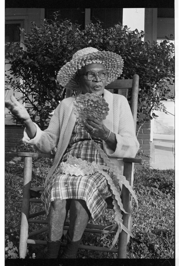 Mrs. F.A. White, Sr. is braiding the corn shuck pieces she has gathered and dried. When the braid gets to be about 15 feet long, she sews it together to make a hat. Photo by Sarah Crosby. See Volume 3, Summer, 1983, pp 59-66. Photograph courtesy of Mississippi Department of Archives and History.