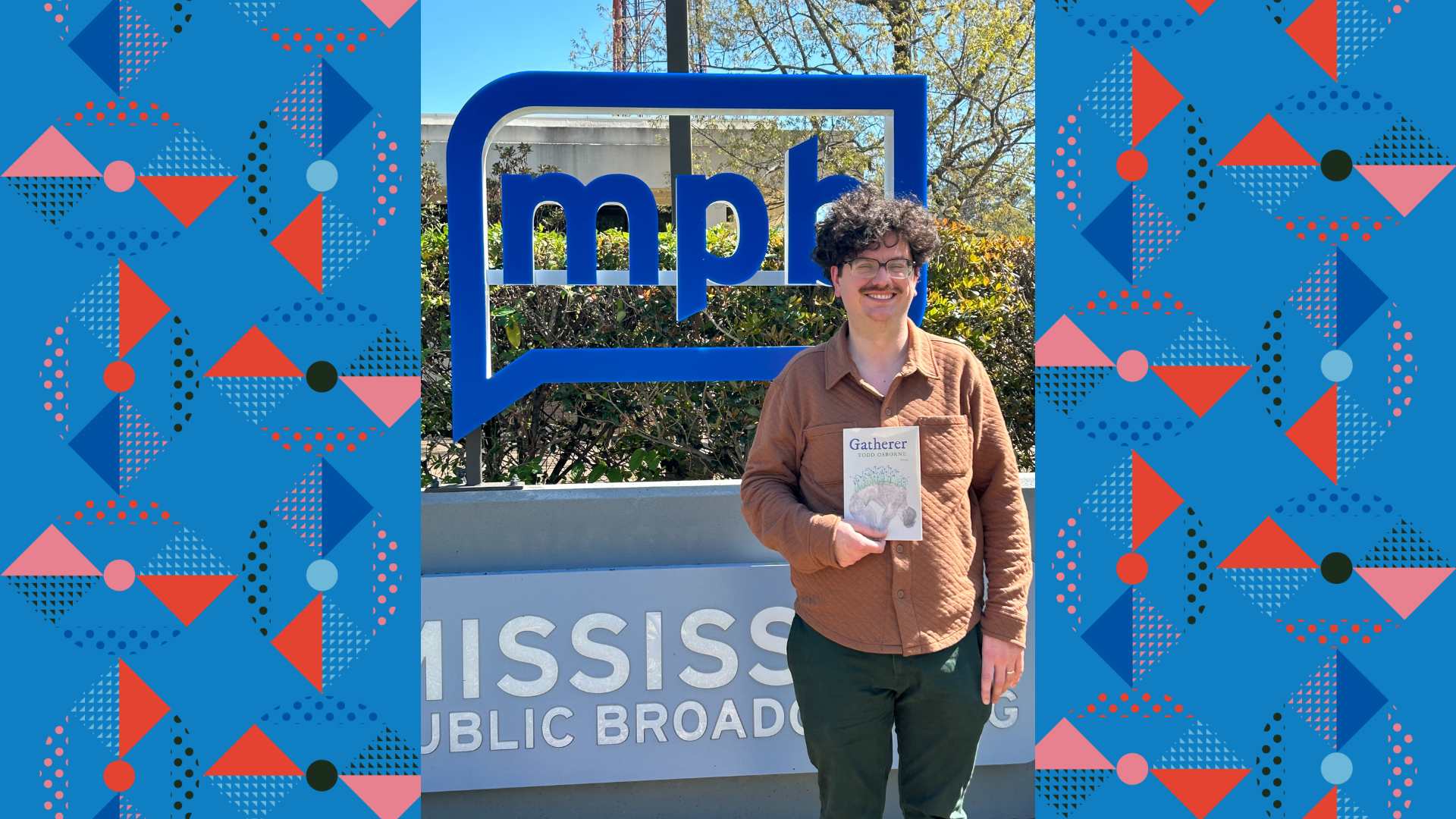 Todd Osborne holding his book in front of the MPB sign.