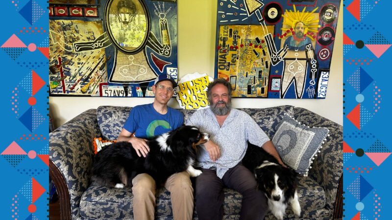 Dan Splaingard and Scott Barretta sitting on a couch with dogs.